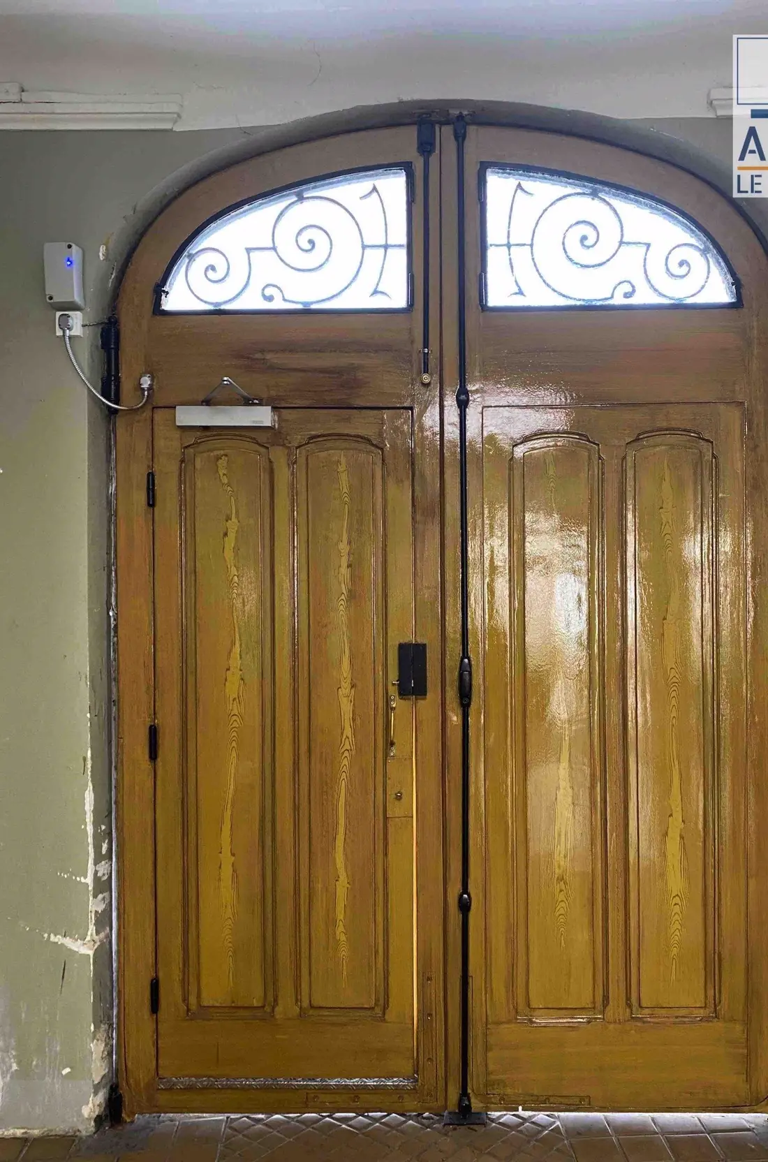 La même porte vue du porche après restauration, vantaux vernis couleur miel