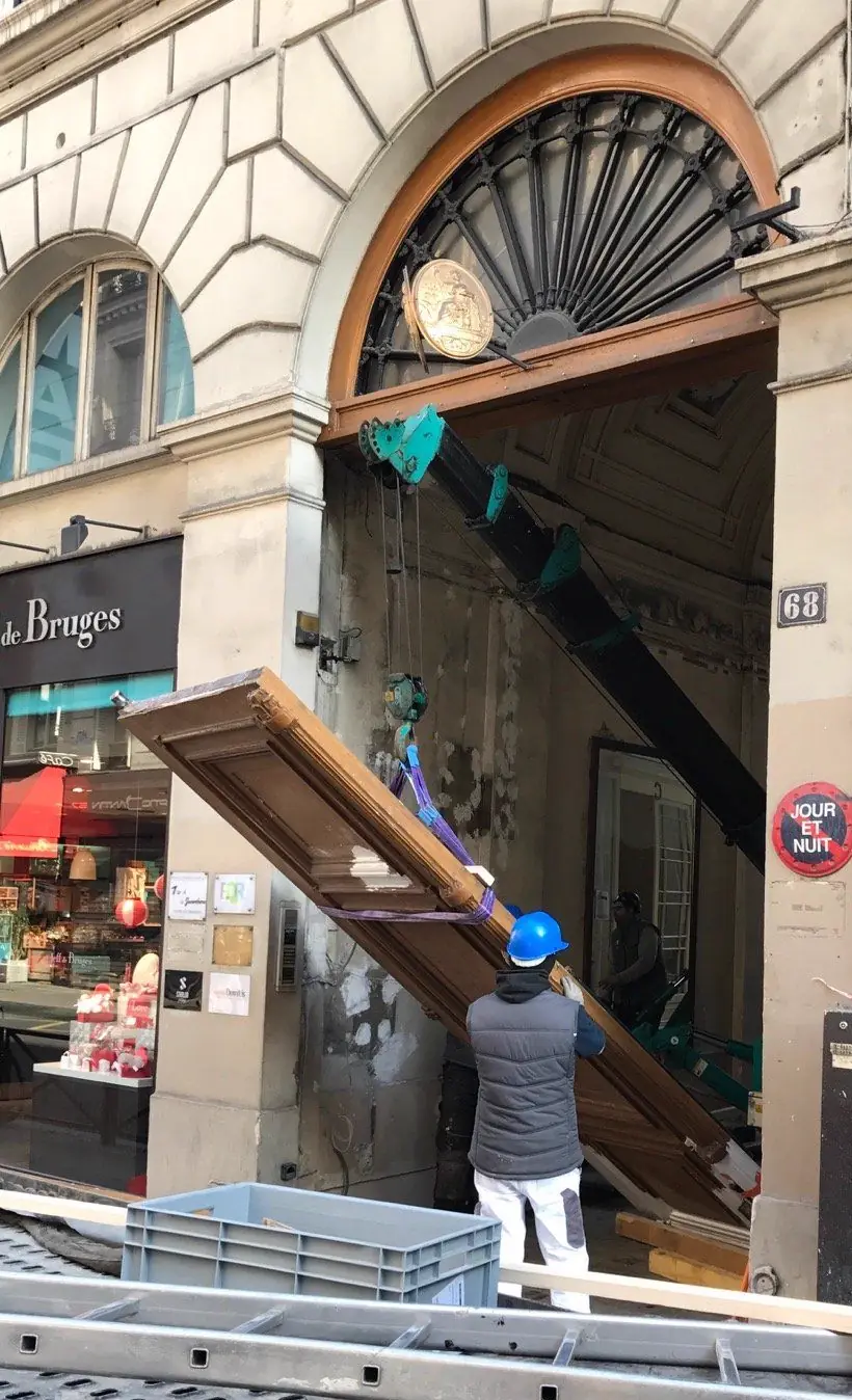 Porte cochère monumentale, 68 rue de la Chaussée-d'Antin, Paris : Repose d'un vantail monumental au palan, sous l'imposte en éventail restée en place.
