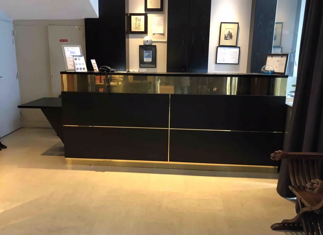 Banque d’accueil laquée noire à bandeau doré, dans le hall d’un hôtel