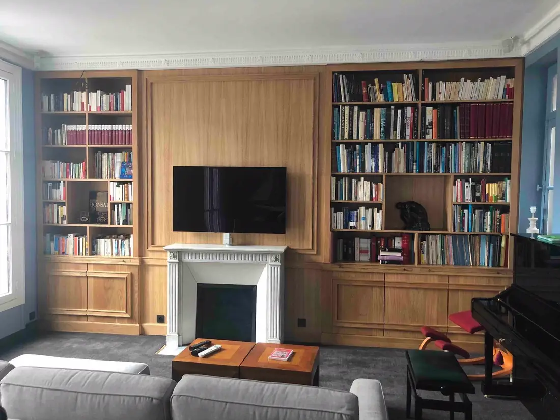 Bibliothèque en chêne montée de part et d’autre d’une cheminée, avec logement pour téléviseur