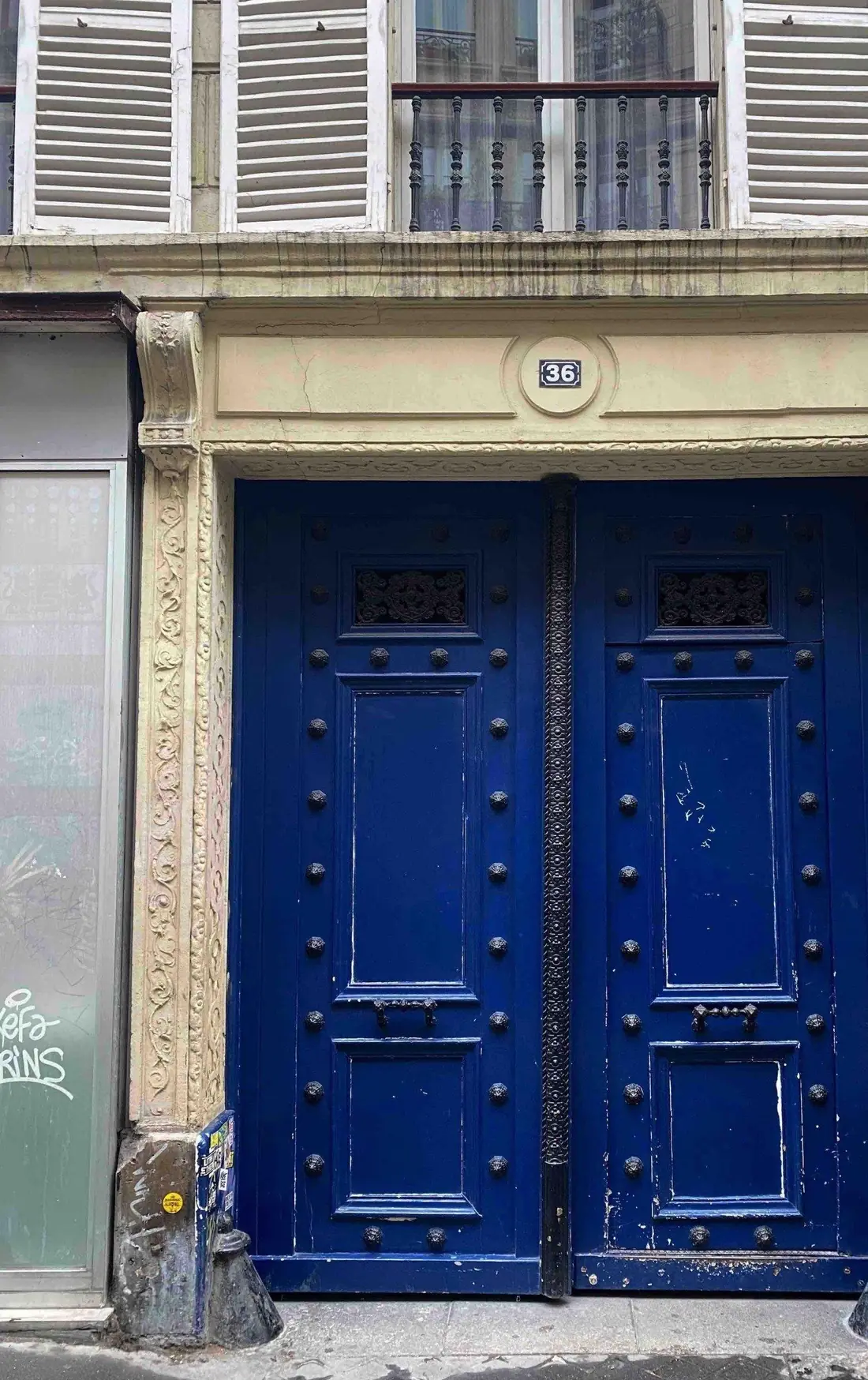 Porte cochère bleue de style Empire, à panneaux cloutés