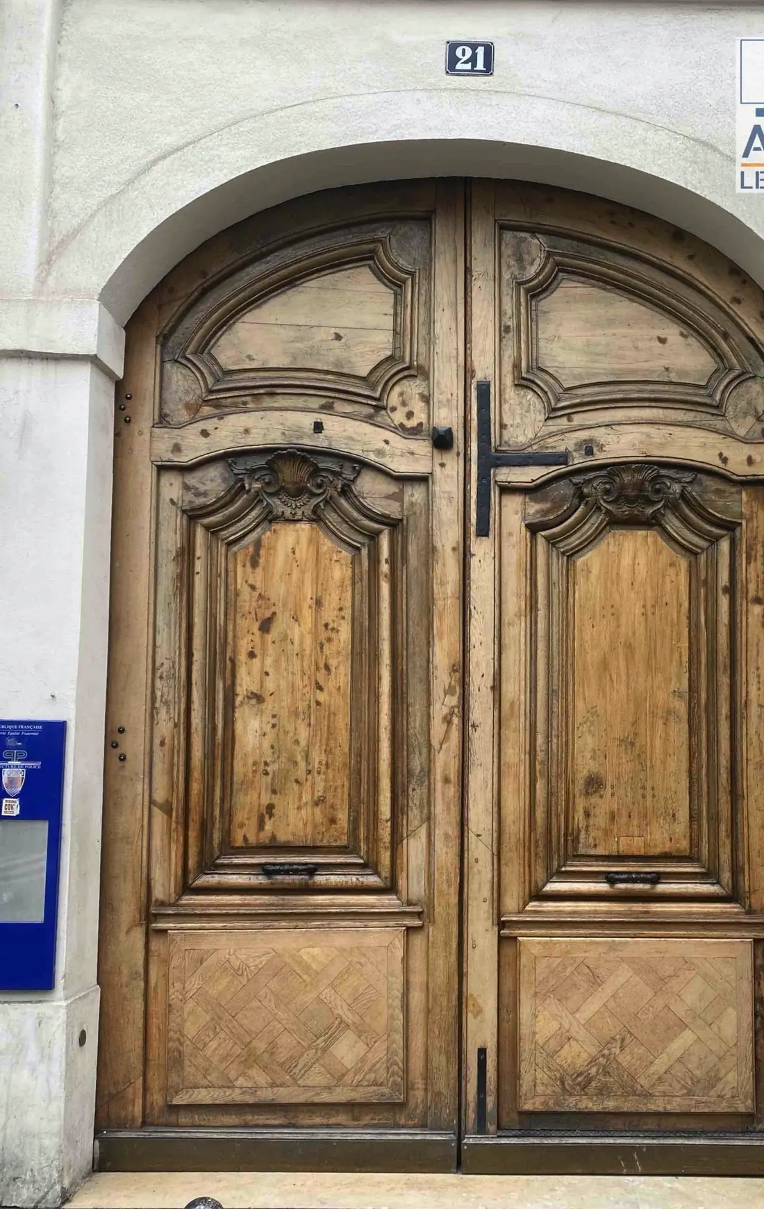 Grande porte cochère cintrée en bois sculpté, deux vantaux ornés