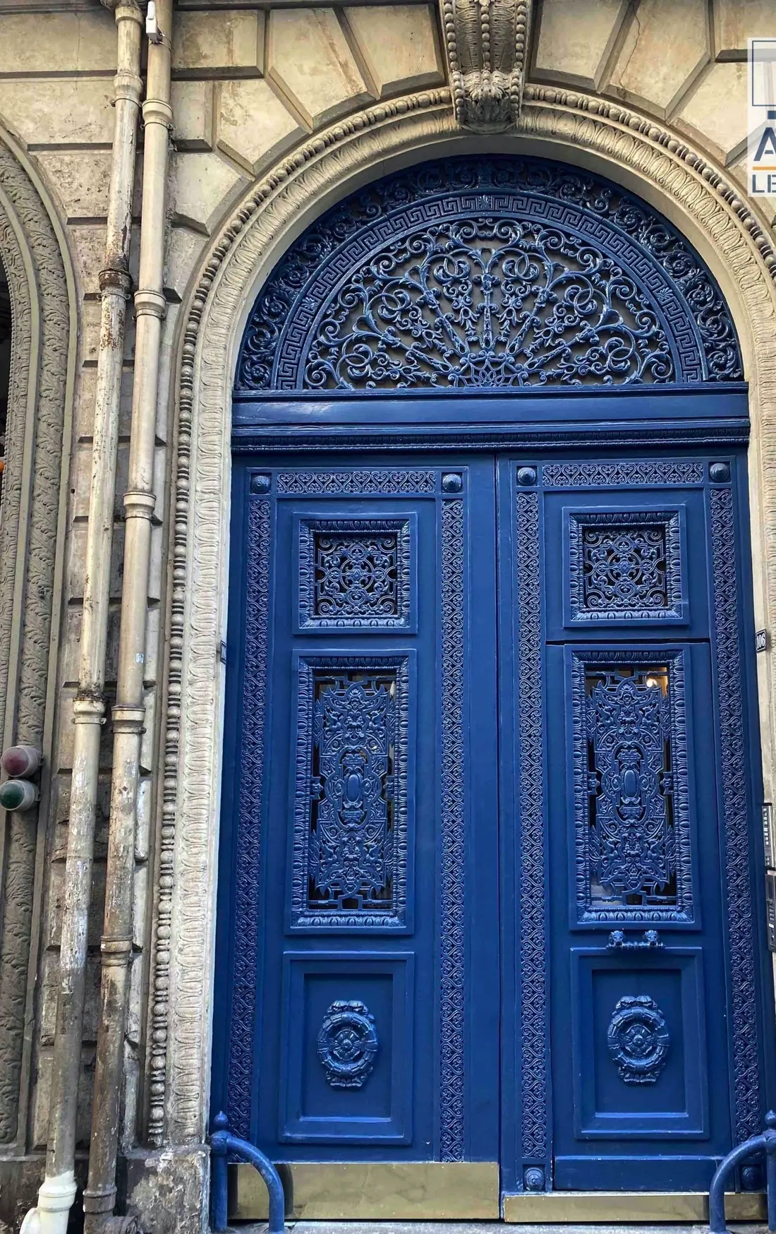 Porte cochère bleue cintrée à imposte grillagée en éventail