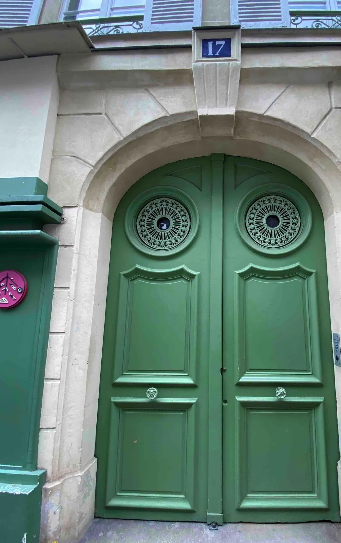 Porte bâtarde verte cintrée à deux vantaux, dans un encadrement de pierre