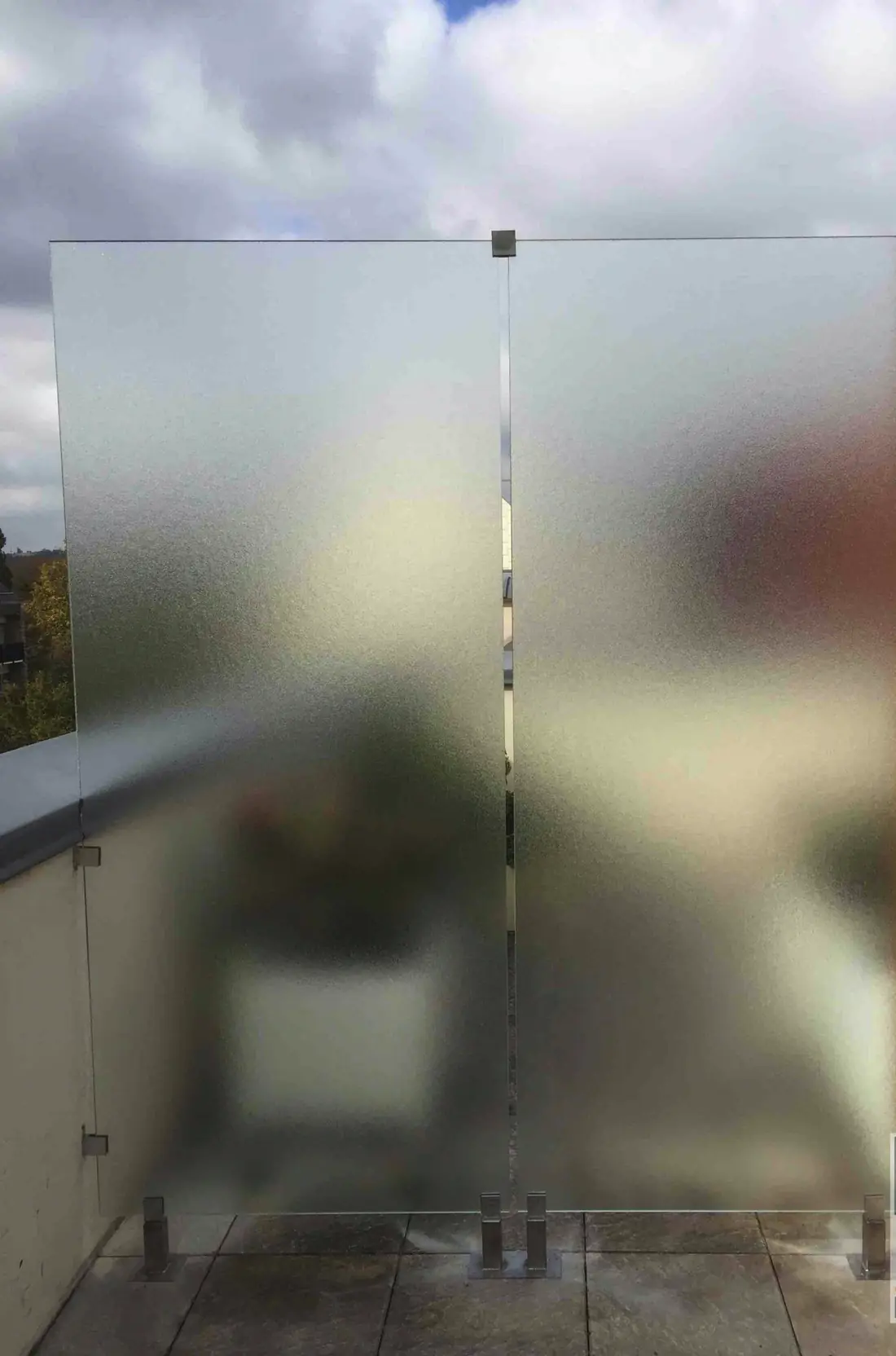 Cloison séparative en verre dépoli montée sur une terrasse