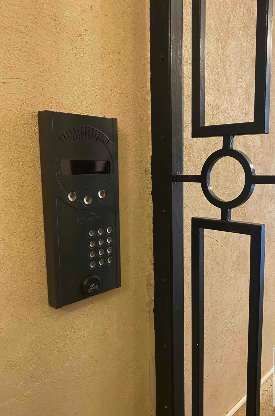 Platine d’interphone à clavier montée à côté du montant d’une grille de sas en acier
