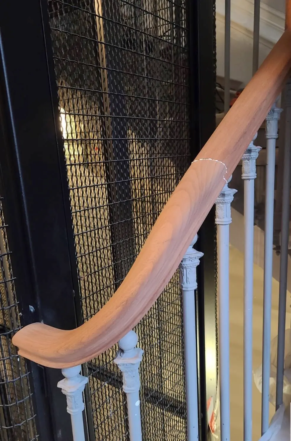 Main courante en bois débillardée suivant la courbe d’un escalier à balustres