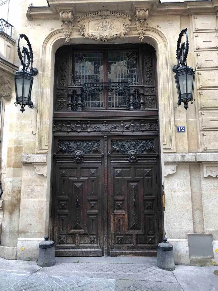 Porte cochère à deux vantaux sculptés, teinte grisée et ferrures encrassées, avant travaux