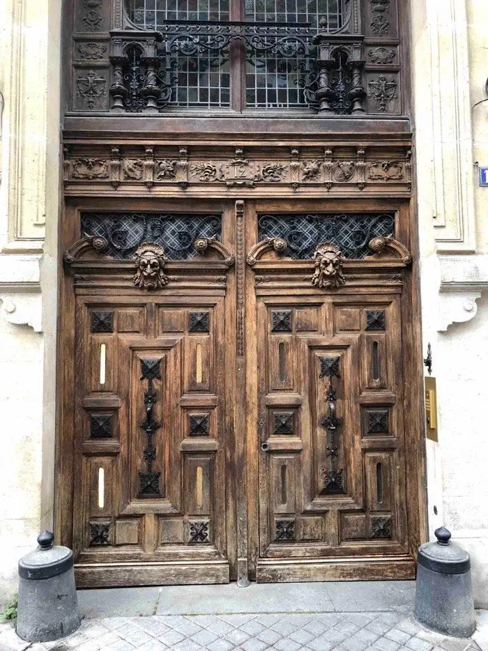 La même porte décapée : chêne nu, mascarons et grilles dégagés