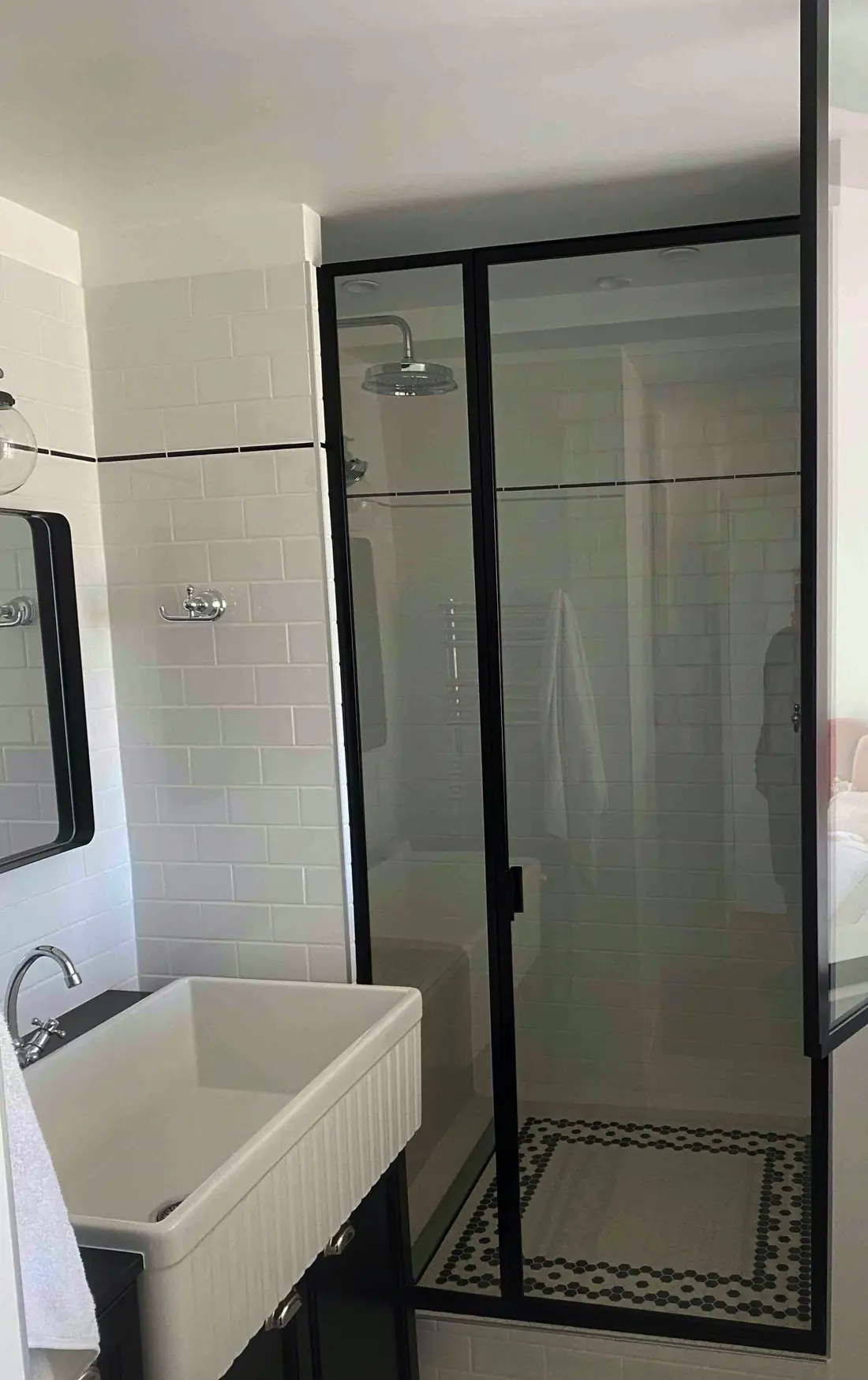 Paroi de douche en acier noir et verre dans une salle d’eau à carreaux de ciment