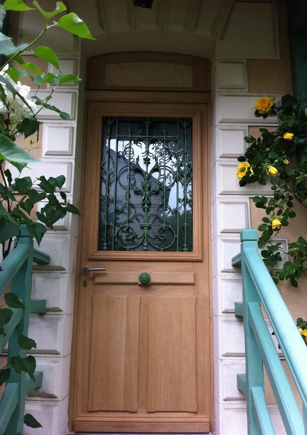 Porte d’entrée de pavillon en chêne à grille ouvragée et vitrage, entre deux rampes
