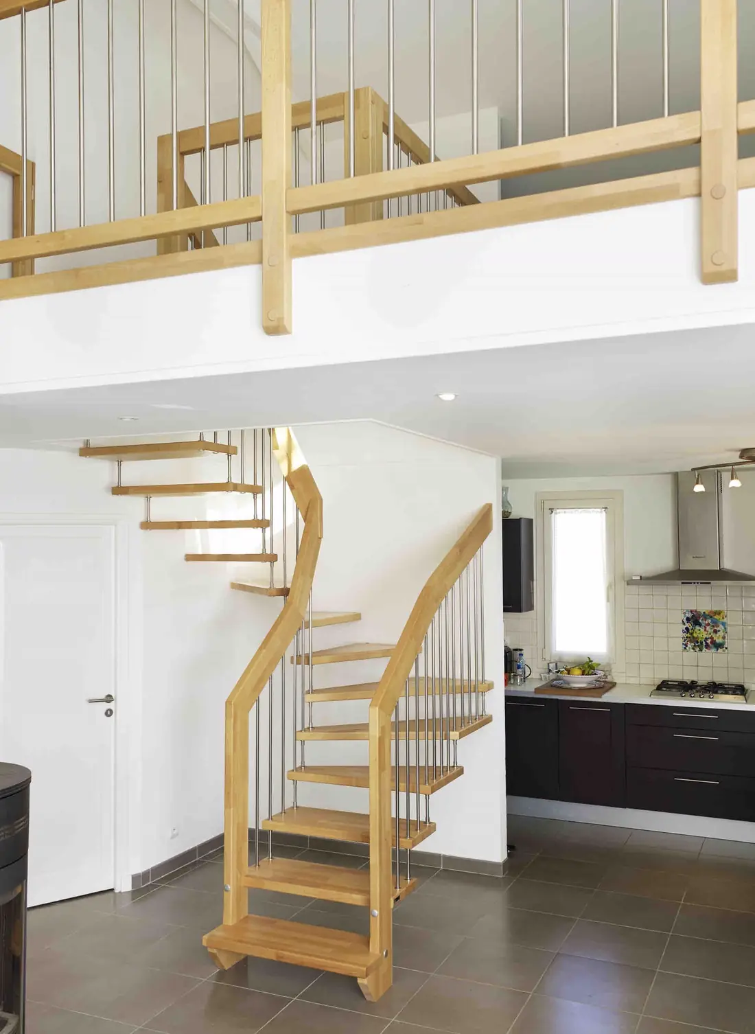 Escalier en bois quart tournant à balustres inox desservant une mezzanine