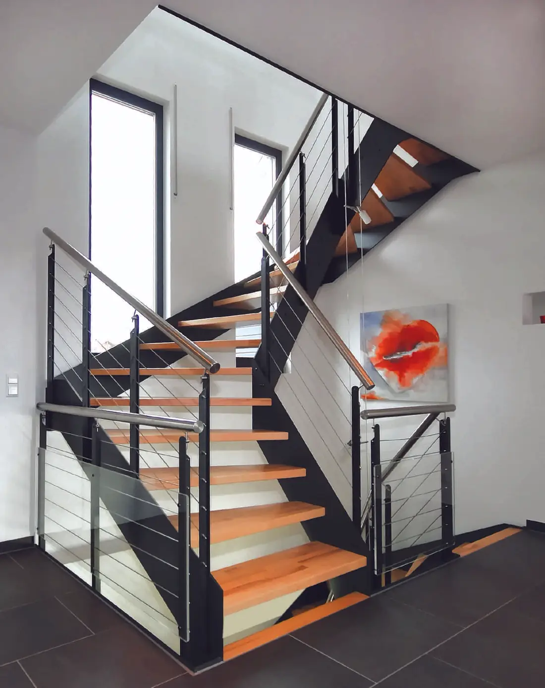 Escalier à double limon acier noir, marches en bois, garde-corps à câbles et verre